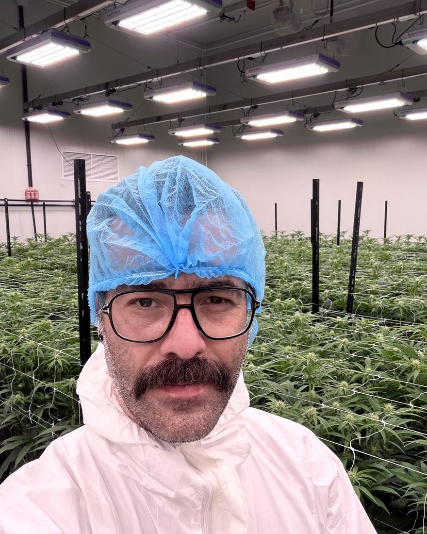 Pato Stein in protective coverall and hair covering inside a licensed cannabis flowering room